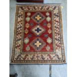 A Caucasian design Turkish rug with geometric motifs on a beige ground 160cm x 134cm