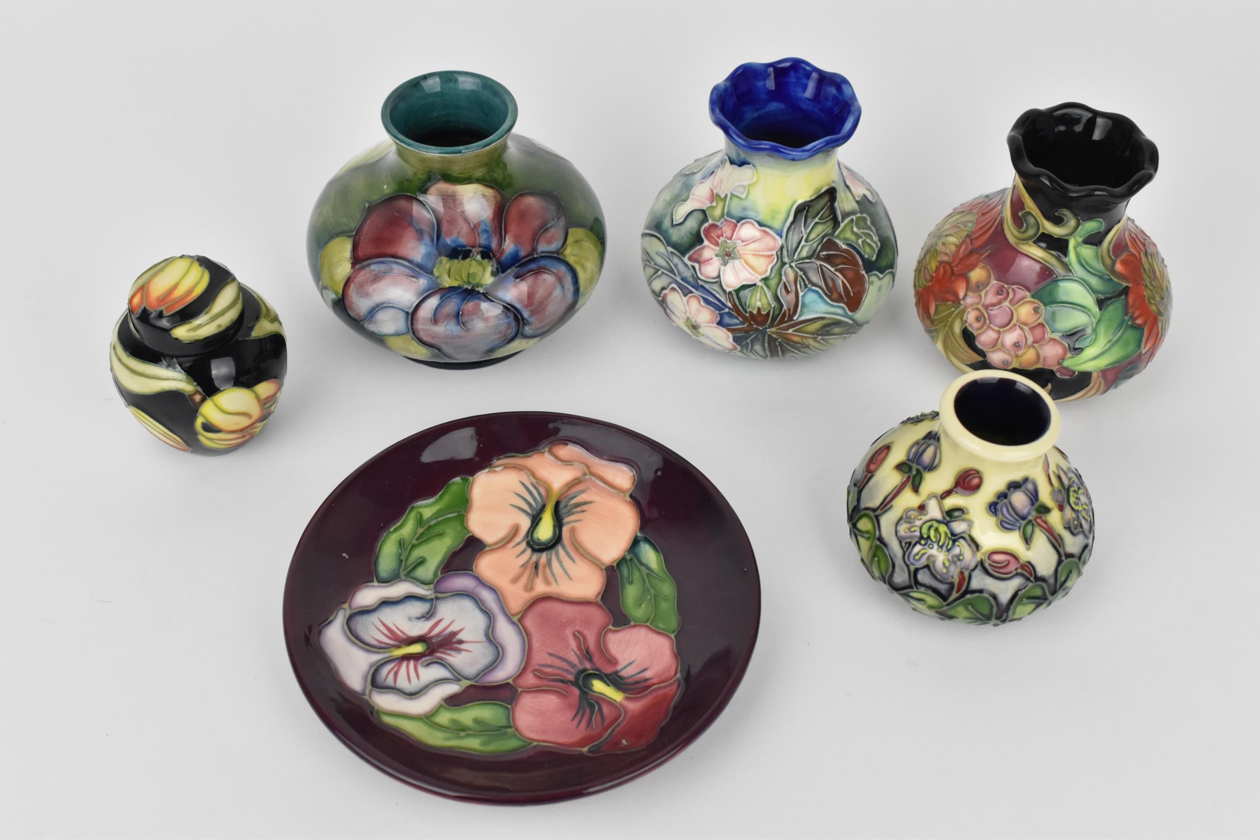 A small collection of Moorcroft ceramics, to include a squat vase in the 'Clematis' pattern on green