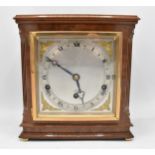 An Elliott 8 day burr walnut mantle clock having a silvered dial with gilt cherub spandrels, the