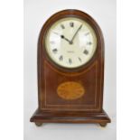 An early 20th century Zenith 8 day mantle clock in a mahogany arched top case with string banding,