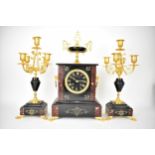 A late 19th century Japy Freres French black slate and rouge griotte marble clock garniture set, the
