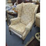 A mid 20th century wingback, floral upholstered armchair on cabriole legs Location: