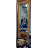 A tall Eastern inspired gold and cream painted wall mirror with incorporated demi lune shelf with