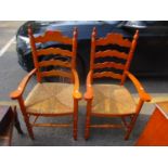 A pair of modern elm rush seated carver chairs Location: