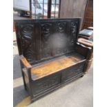 An 18th century and later oak carved panelled settle with a hinged seat, 129cm h x 133cm w Location: