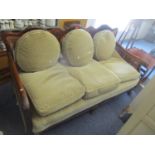 An early 20th century Bergere suite consisting of a sofa and two matching armchairs, having scroll