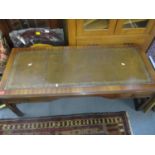 A reproduction mahogany two drawer coffee table with inset gilt tooled leather top, two frieze