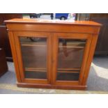 A Victorian walnut two door glazed cabinet with three loose shelves and on a plinth base, 113cm h