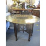 An early 20th century Indian occasional table with an engraved and painted moulded brass tray and