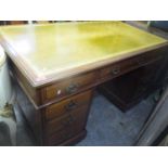 A late 19th/early 20th century walnut twin pedestal desk having a leather topped scriber and nine