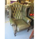 A reproduction green leather button wingback armchair Location: