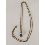 A gold coloured necklace marked 9ct having a diamond and sapphire pendant, in a floral form, total