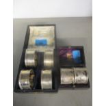 A cased set of four Edwardian silver napkin rings with engraved floral decoration, Birmingham