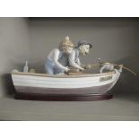 A Lladro model of a grandfather and boy fishing in a rowing boat, 22.5cm h x 39cm w, including stand