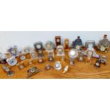 A collection of miniature clocks in various forms to include metal, ceramics and plaster and a