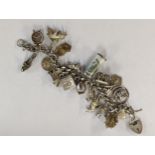 A silver charm bracelet having a silver heart padlock clasp with approx 20 silver and white metal