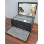 A modern jewellery box having a hinged lid with inset mirror and three drawers Location: