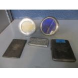 A group of silver items to include two small circular photograph frames, a cigarette case with