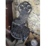 A black painted cast metal garden table and a chair