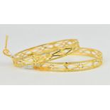 A pair of 22ct yellow gold wedding bangles, of circular form with pierced decorations and textured