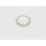 A 9ct white gold and diamond half eternity ring, with seven small bezel set diamonds, hallmarked