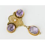 A Victorian Etruscan style yellow metal, amethyst and pearl brooch, with pierced foliate central