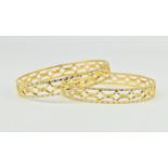 A pair of 22ct yellow gold wedding bangles, of circular form with two-tone pierced decorations and