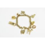 A 9ct yellow gold charm bracelet, the curb link chain holding various charms such as a deer, the Arc