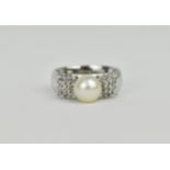 An 18ct white gold, diamond and pearl dress ring, the central pearl flanked with square shaped