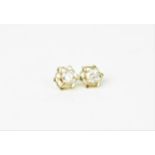 A pair of yellow metal and diamond solitaire stud earrings, with yellow metal pierced floral