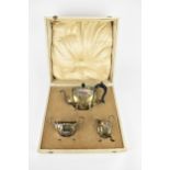 A cased George V silver tea set by Henry Matthews, Birmingham 1914, comprising a small teapot, a