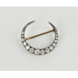 A rose metal, white metal and diamond crescent brooch, set with twenty-one graduated diamonds, the