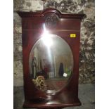 A mahogany framed wall mirror with shelf and carved motif Location: