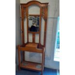 An early 20th century hall stand with coat and hat hooks and two umbrella drip trays below Location: