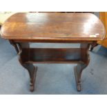 An oak table with integral book trough below, 74cm h x 69cm w x 33cm d, having carved side