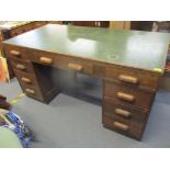 A mid 20th century oak twin pedestal desk having nine inset drawers to the front and open