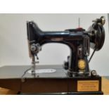 A 1955 Singer 222k featherweight free-arm sewing machine and accessories in original case, serial