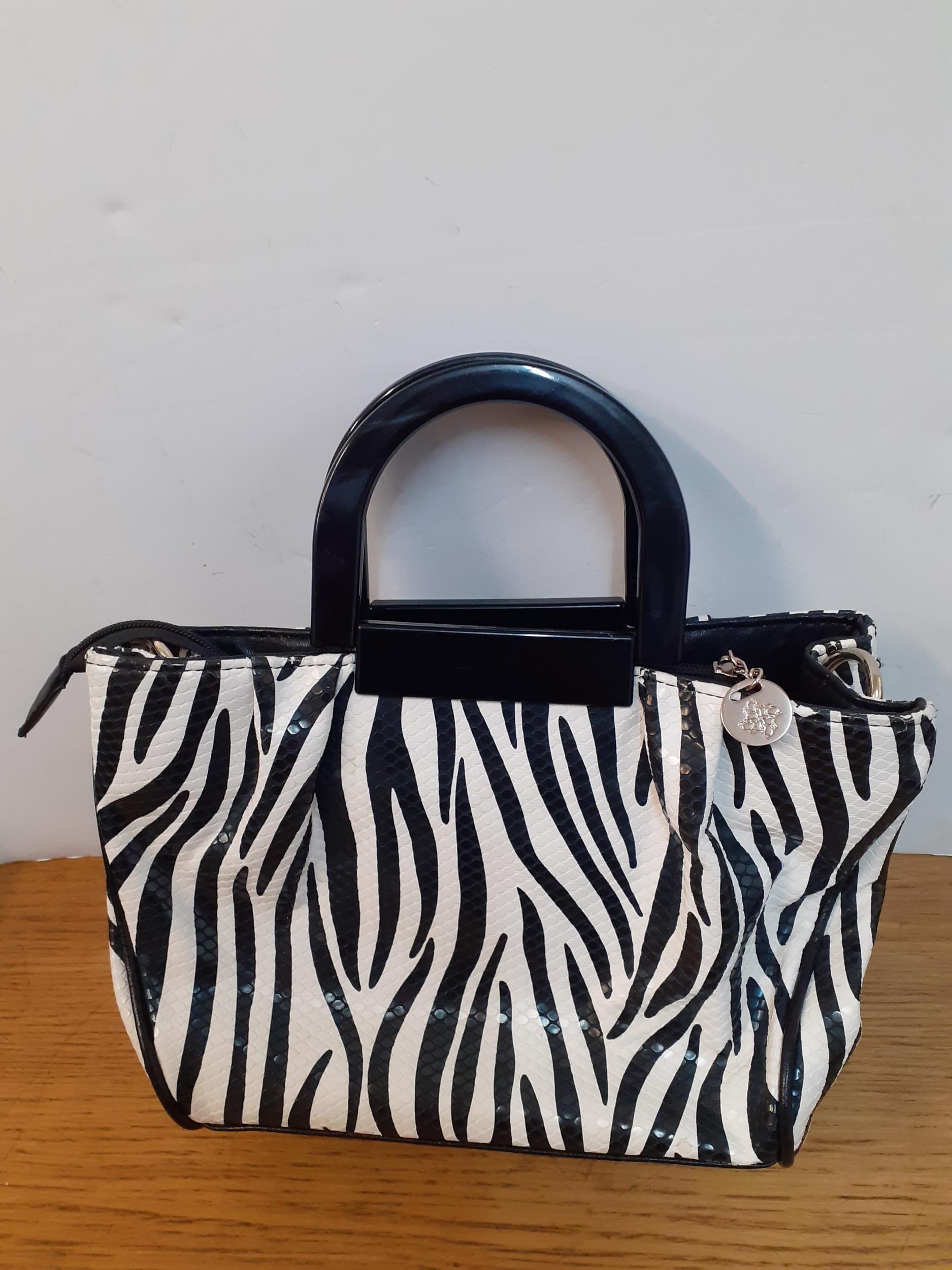 Bulaggi- Two modern bags, one in a zebra print with black resin handles and red interior having 2 - Image 3 of 4