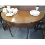 A Regency mahogany dining table comprising two demi lune ends, on turned tapered legs, 72cm x