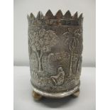 A white metal embossed pot decorated with figures, trees and building, on later silver plated