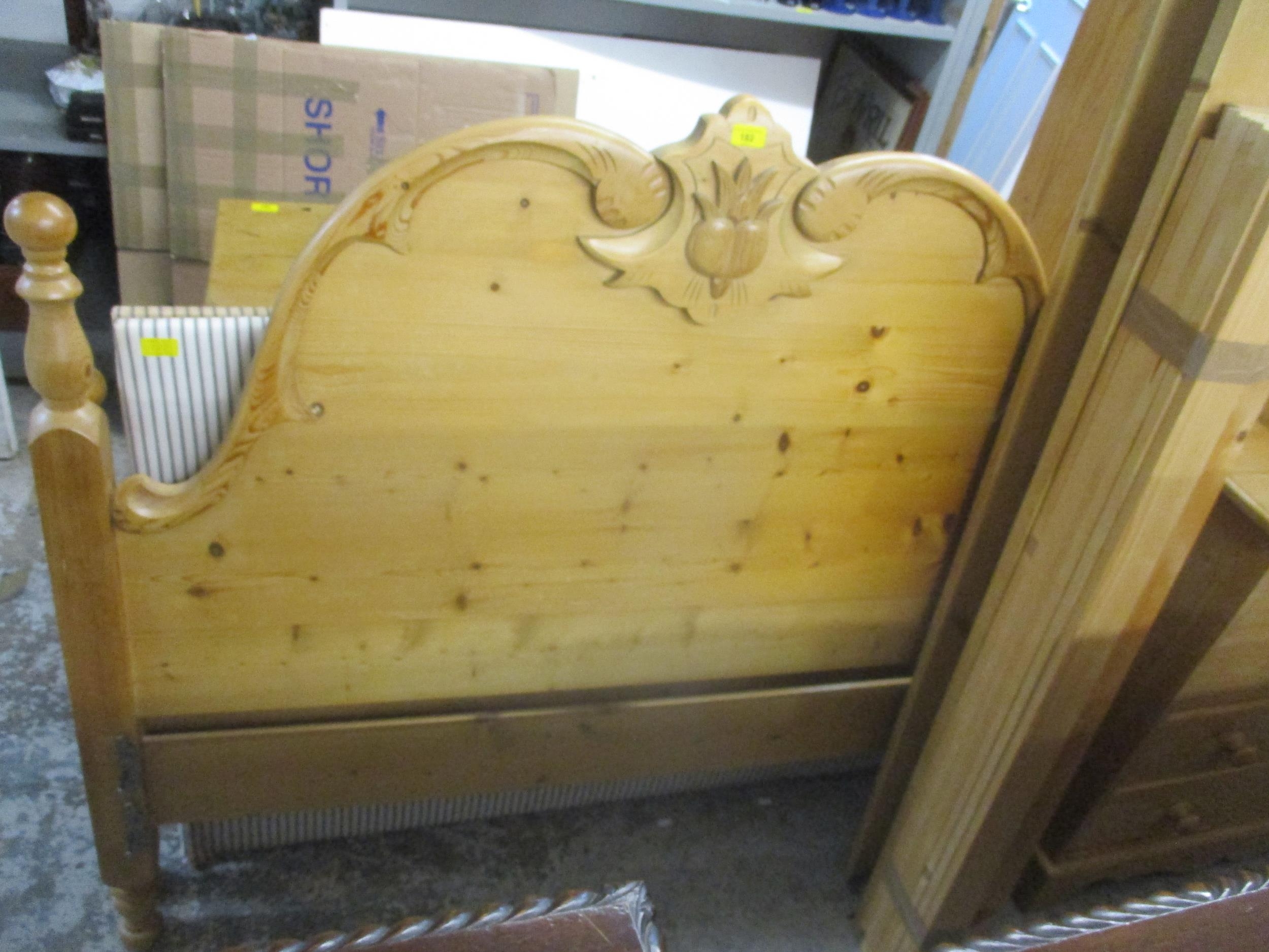 A contemporary pine carved and turned double bed head and foot board with slats, and a pine