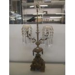 An early 20th century gilt metal two branch candelabrum with crystal drops, star shaped finial and