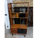A mid 20th century G-Plan teak and ebonized room divider with shelves, sliding doors, drawers and