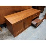 A mid 20th century teak cabinet with a pair of doors, a drawer and a slide, 54cm h, 131 cm w
