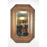 A mid-century carved oak framed gypsy mirror, rectangular mirrored plate with canted corners, having