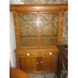 A contemporary pine side cabinet, the overhanging cornice over twin astrigal glazed display doors