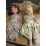 Two 1950s composition dolls, on with brown sleeping eyes and fair hair, the other with blue sleeping