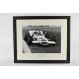 A signed reprinted photograph of Vic Elgood, racing in a McLaren at the British Grand Prix at