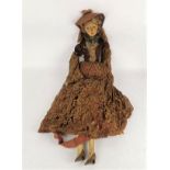 An early 20th century doll with painted fabric face, a flat back head and a hanging ring,