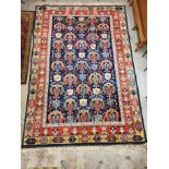 A Turkish rug with repeated geometric motifs in pastel blue, red, yellow and green, 310cm x 210cm